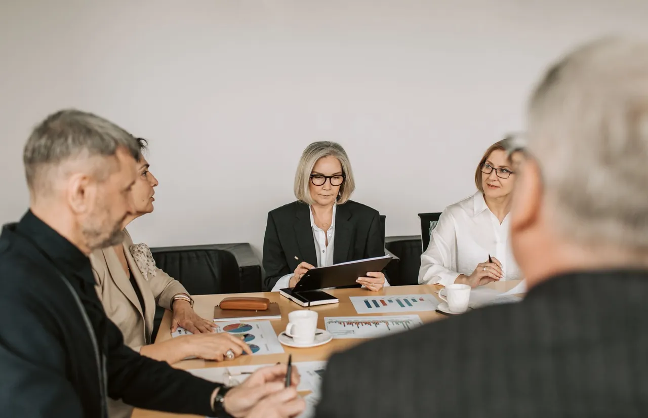 Consultants reviewing plans with clients around a meeting table